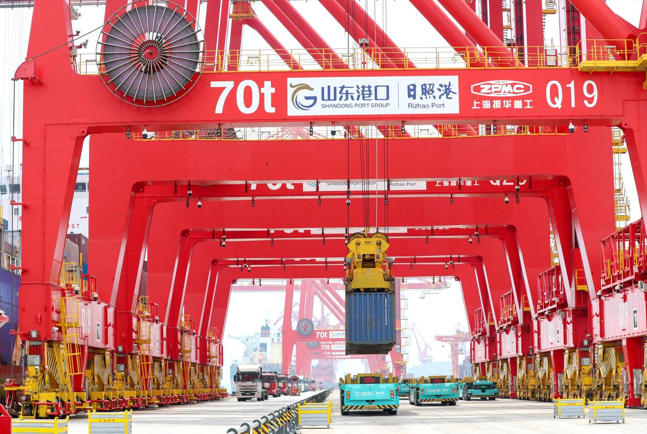 5月22日,在山东港口日照港顺岸式全自动化集装箱码头,智能导引运输车在运送货物。(张进刚 摄1)电话13854260100